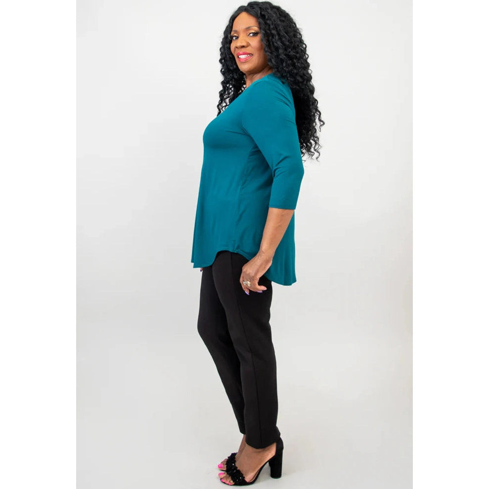 Blue Sky Jazz 3/4 Sleeve Top in Teal shown on a model wearing black leggings against a white background, from the side view.