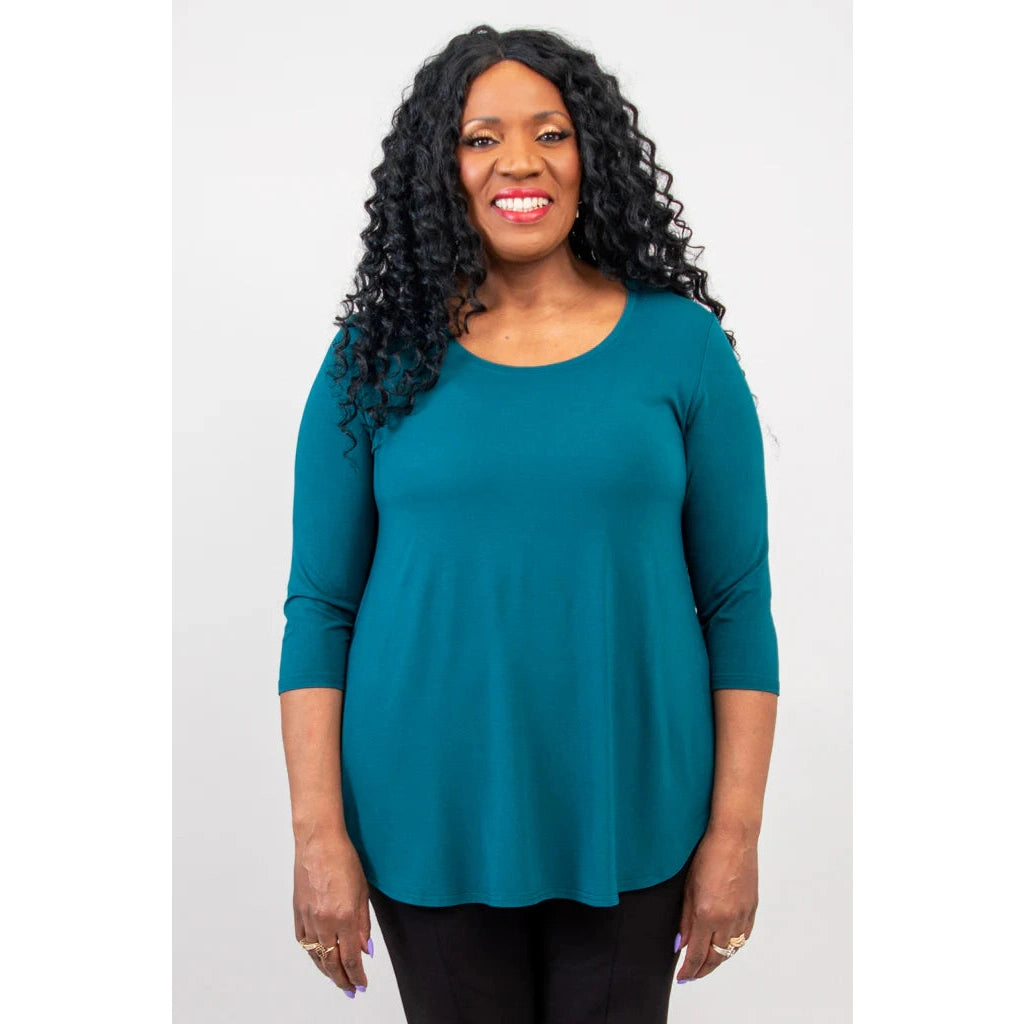 Blue Sky Jazz 3/4 Sleeve Top in Teal shown on a model wearing black leggings against a white background, from the front view.