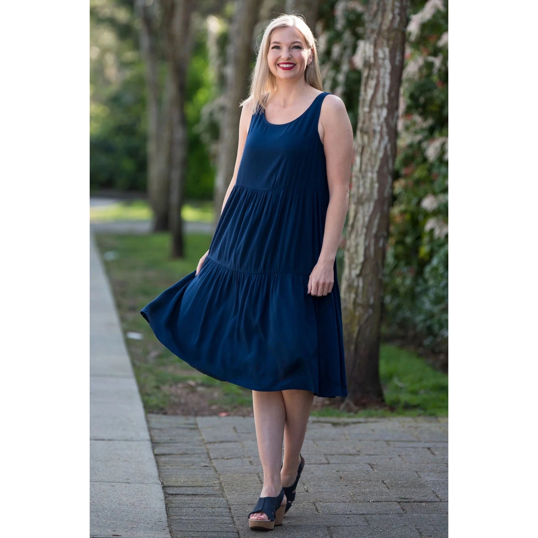 Blue Sky Juni Dress in Indigo shown on a model against an outdoor background, from the front view.
