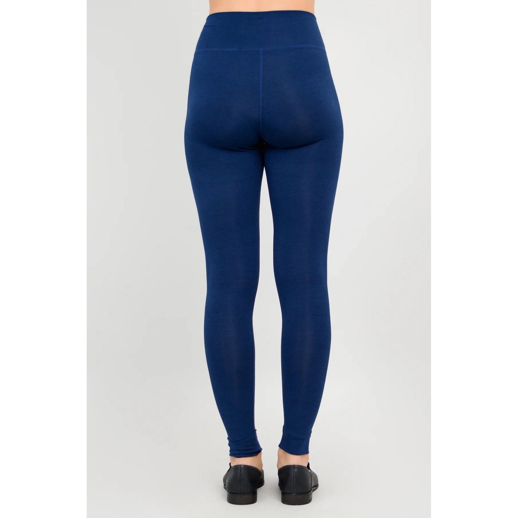 Blue Sky Riley Leggings in Indigo shown on a model against a white background, from the back view.