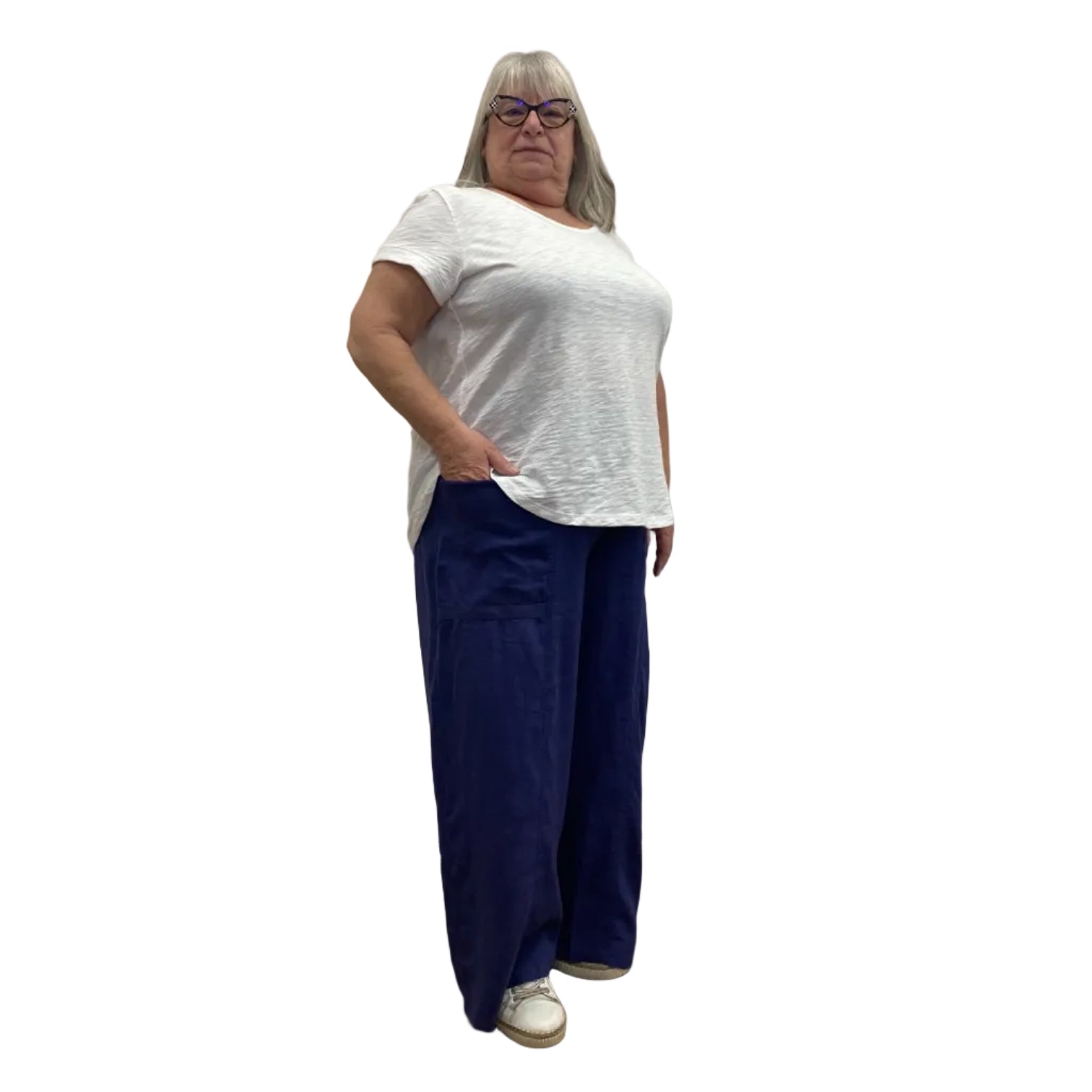 Woman wearing the Escape Cuff Sleeve Hi-Lo White T-shirt paired with navy pants against a white background.