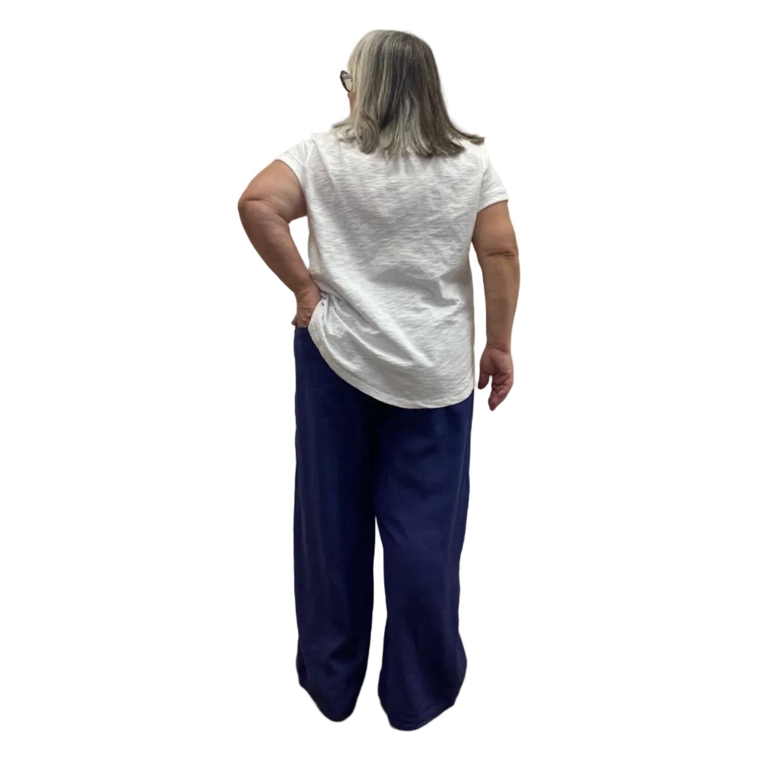 Woman wearing the Escape Cuff Sleeve Hi-Lo White T-shirt paired with navy pants against a white background.