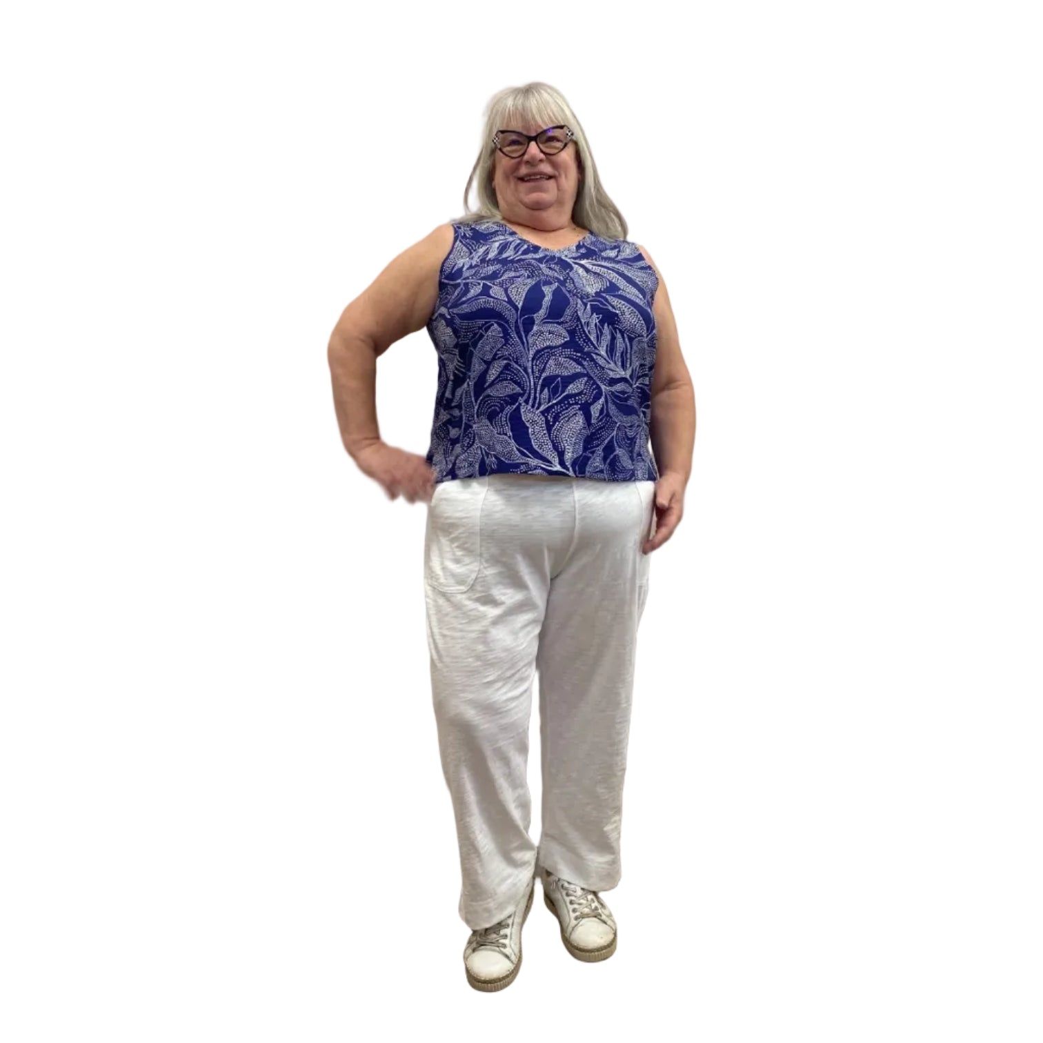 Woman wearing Escape Pocket Trousers in white, paired with a navy and white floral tank, against a white background.
