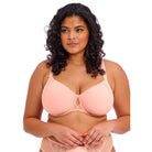 A women wearing a light link bra and panty set against a white back ground. 