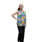 Woman wearing a colorful sleeveless top with abstract patterns on a white background