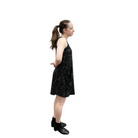 Woman wearing a black dress with white patterns on a white background