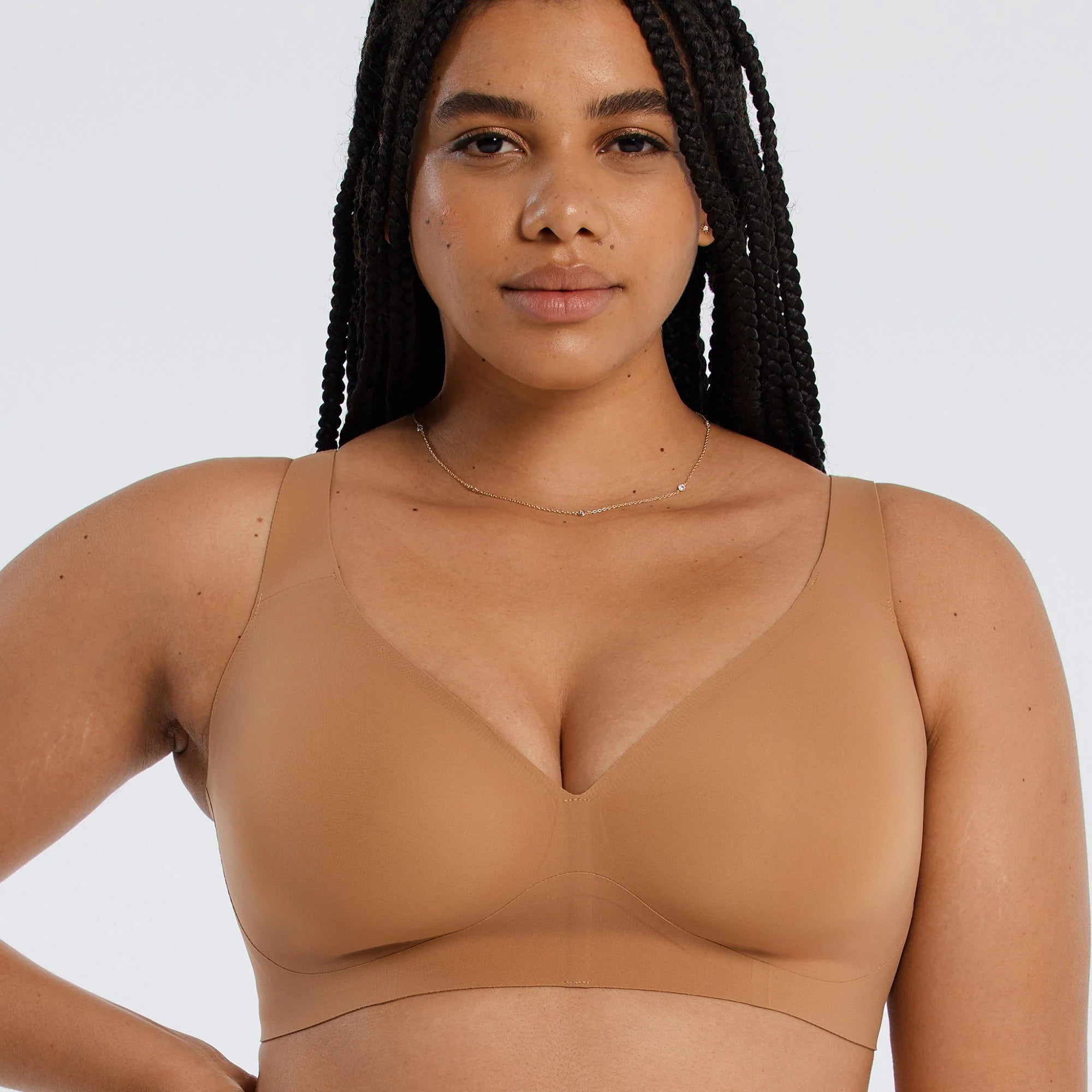 Woman wearing a beige bra against a white background