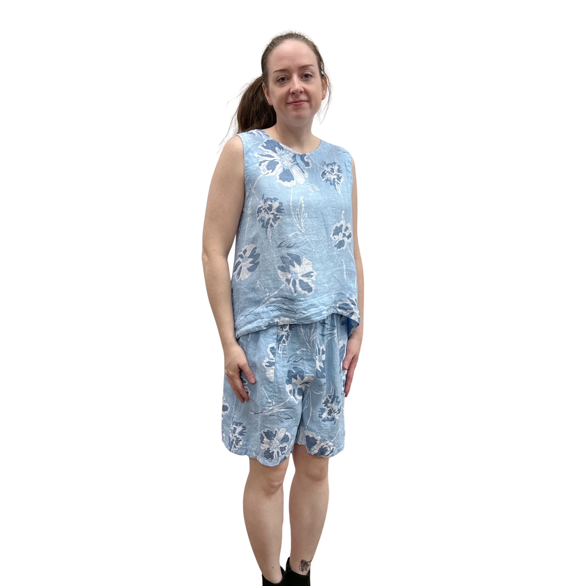 Woman wearing a blue floral tank and short set on a white background