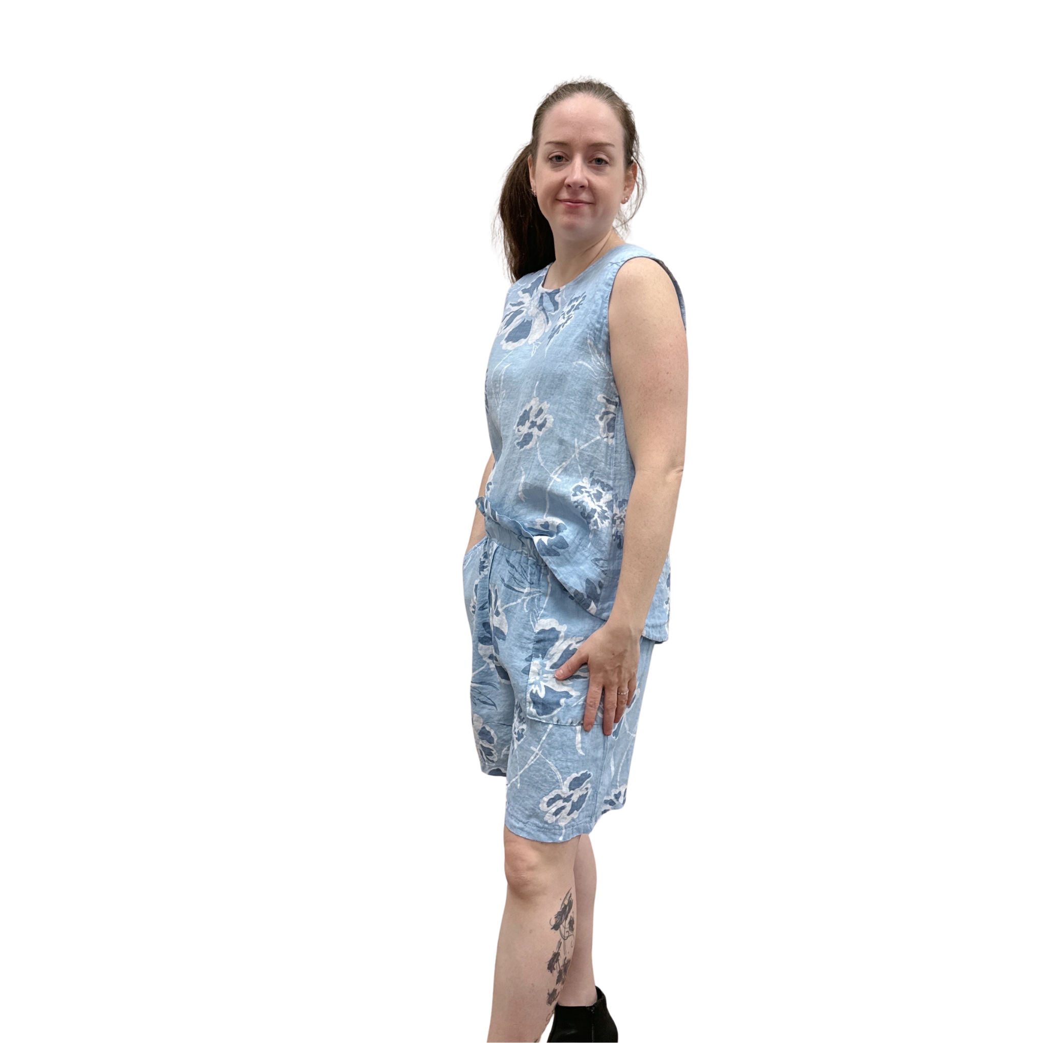 Woman wearing a blue floral tank and short set on a white background