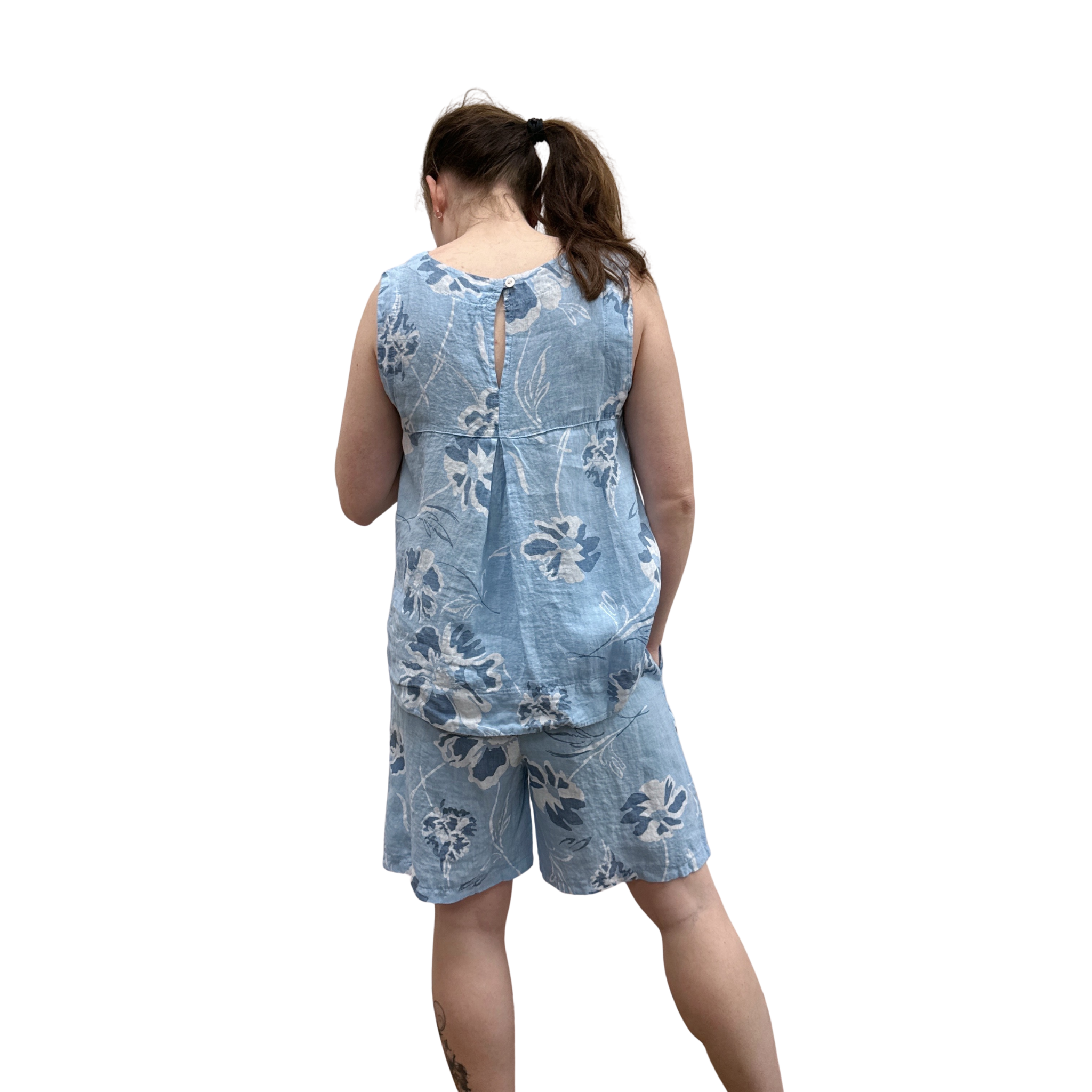 Woman wearing a blue floral tank and short set on a white background