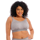 A woman wearing a grey wireless bra against a white background. 