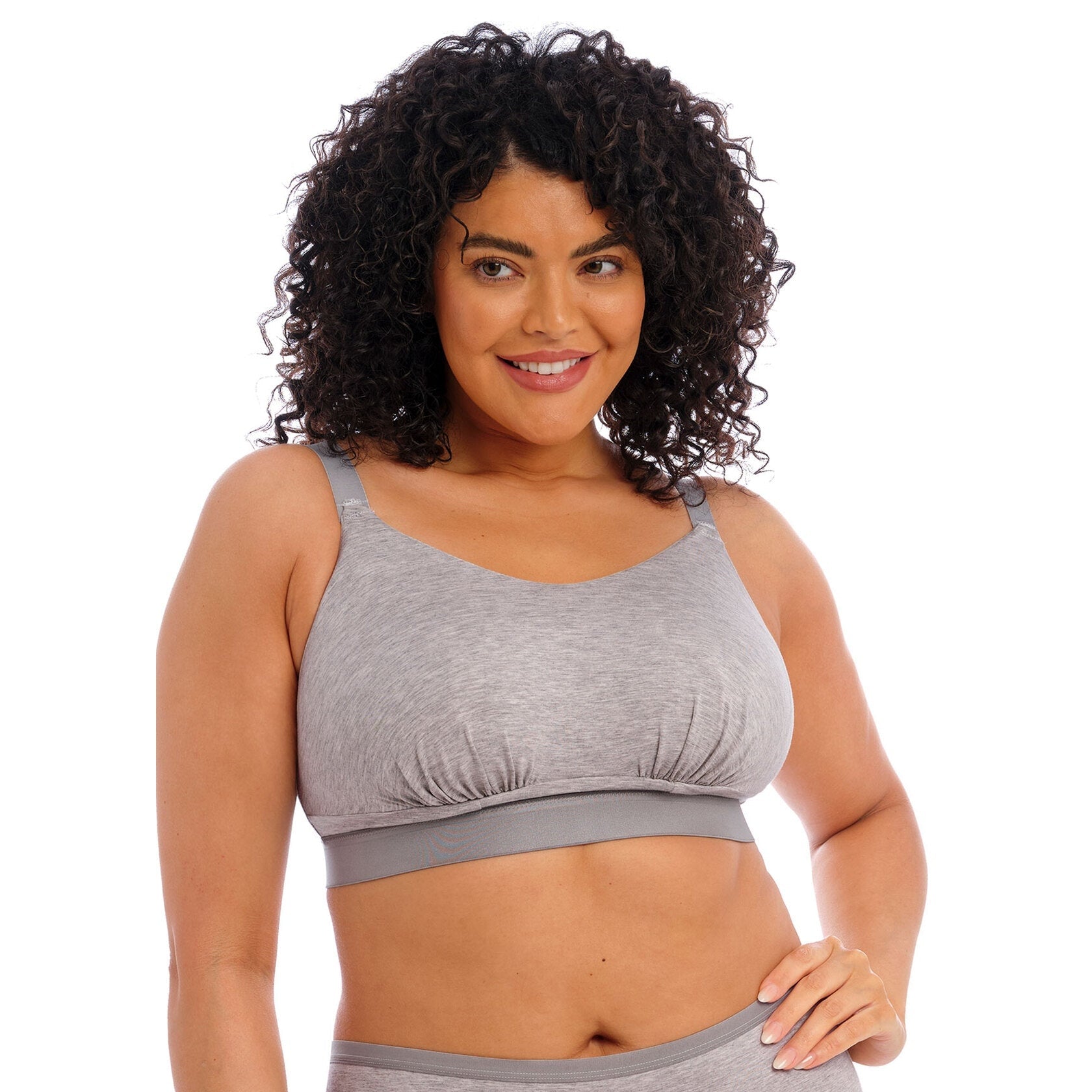 A woman wearing a grey wireless bra against a white background. 