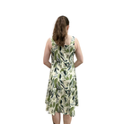 Woman wearing a green leaf-patterned dress on a white background