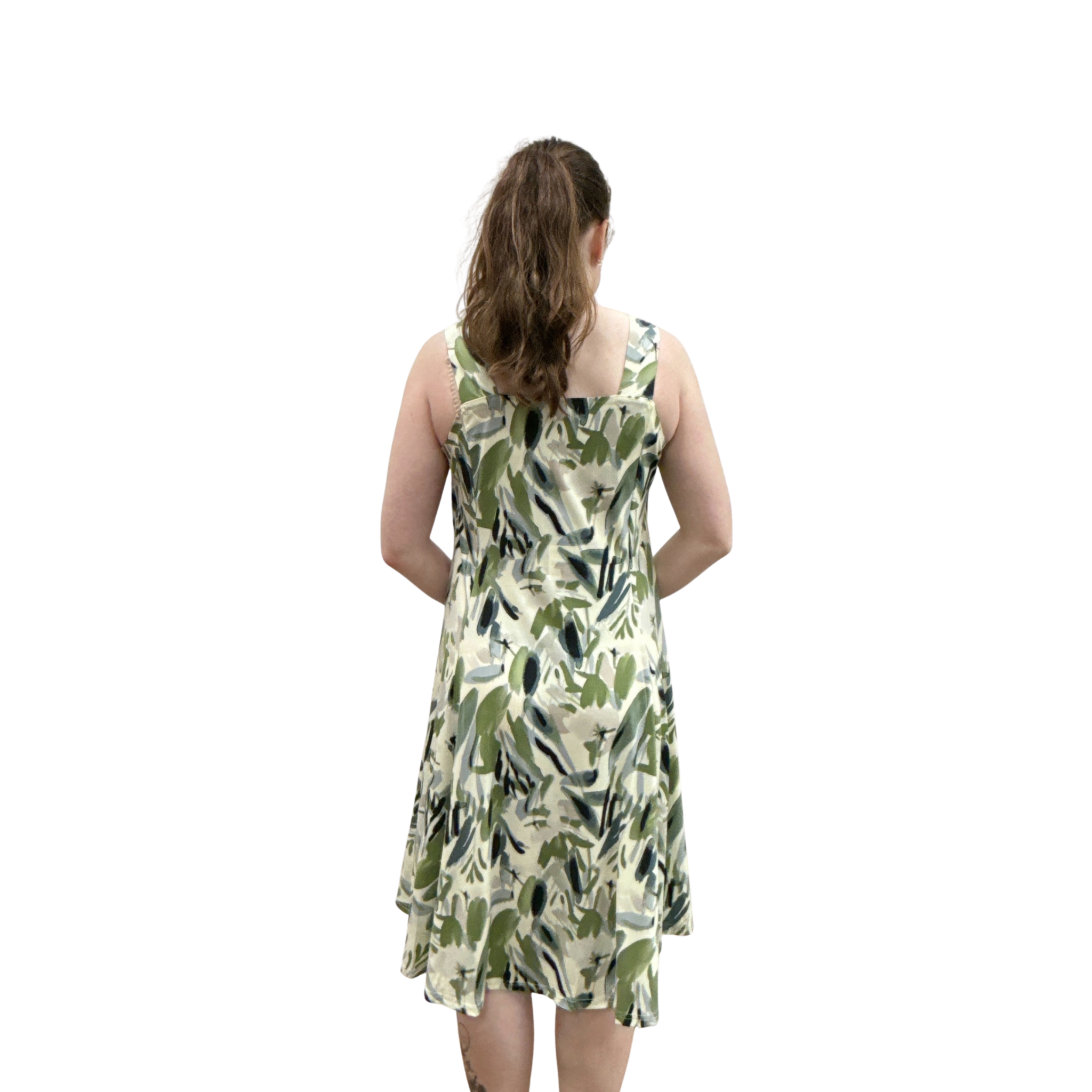 Woman wearing a green leaf-patterned dress on a white background