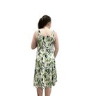 Woman wearing a green leaf-patterned dress on a white background