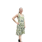 Woman wearing a green leaf-patterned dress on a white background