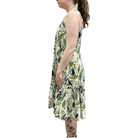 Woman wearing a sleeveless dress with leaf pattern on a white background