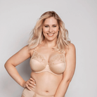 Woman wearing a beige lingerie set on a plain background