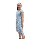 Woman wearing a light blue floral dress on a white background