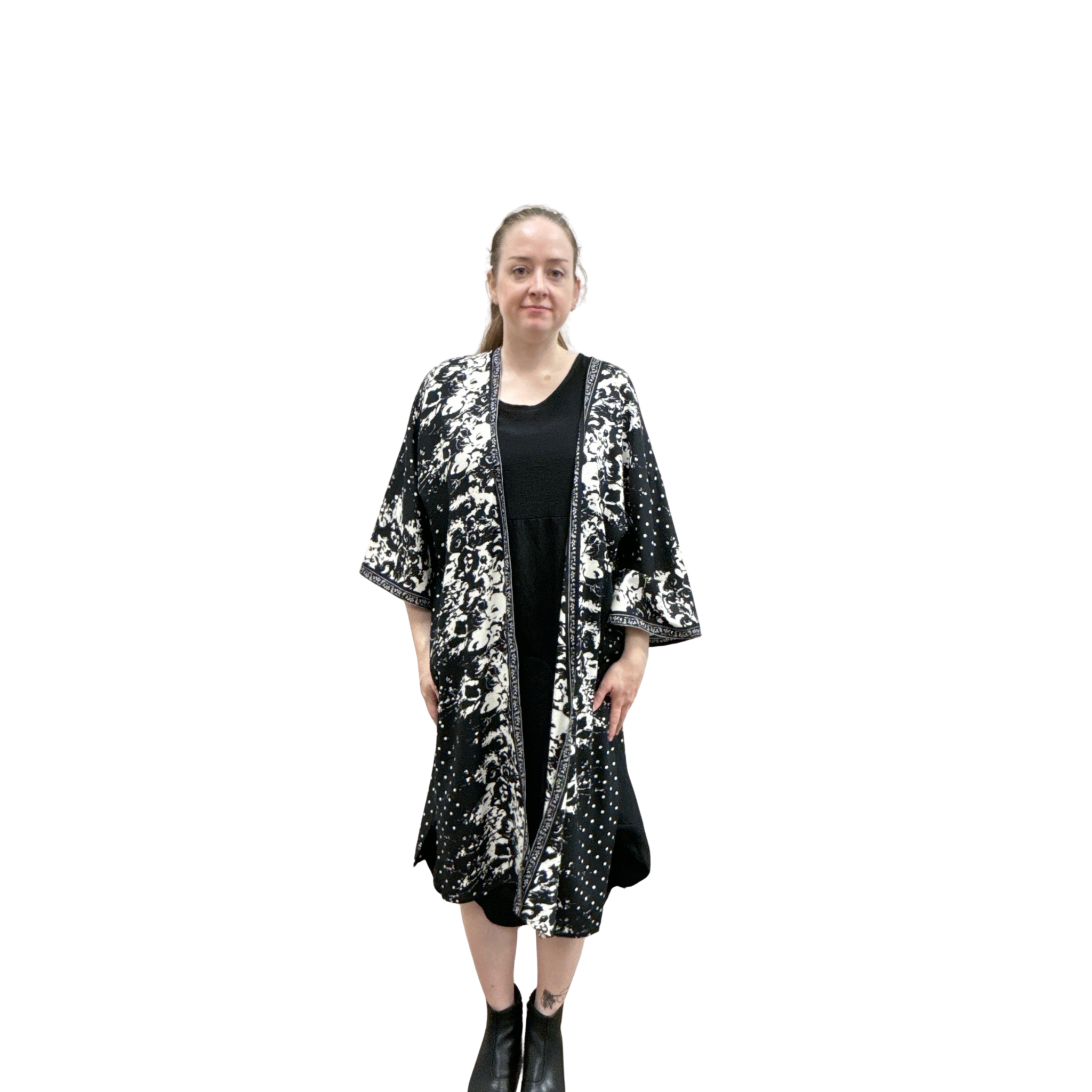 Woman wearing a black and white patterned kimono-style jacket on a white background