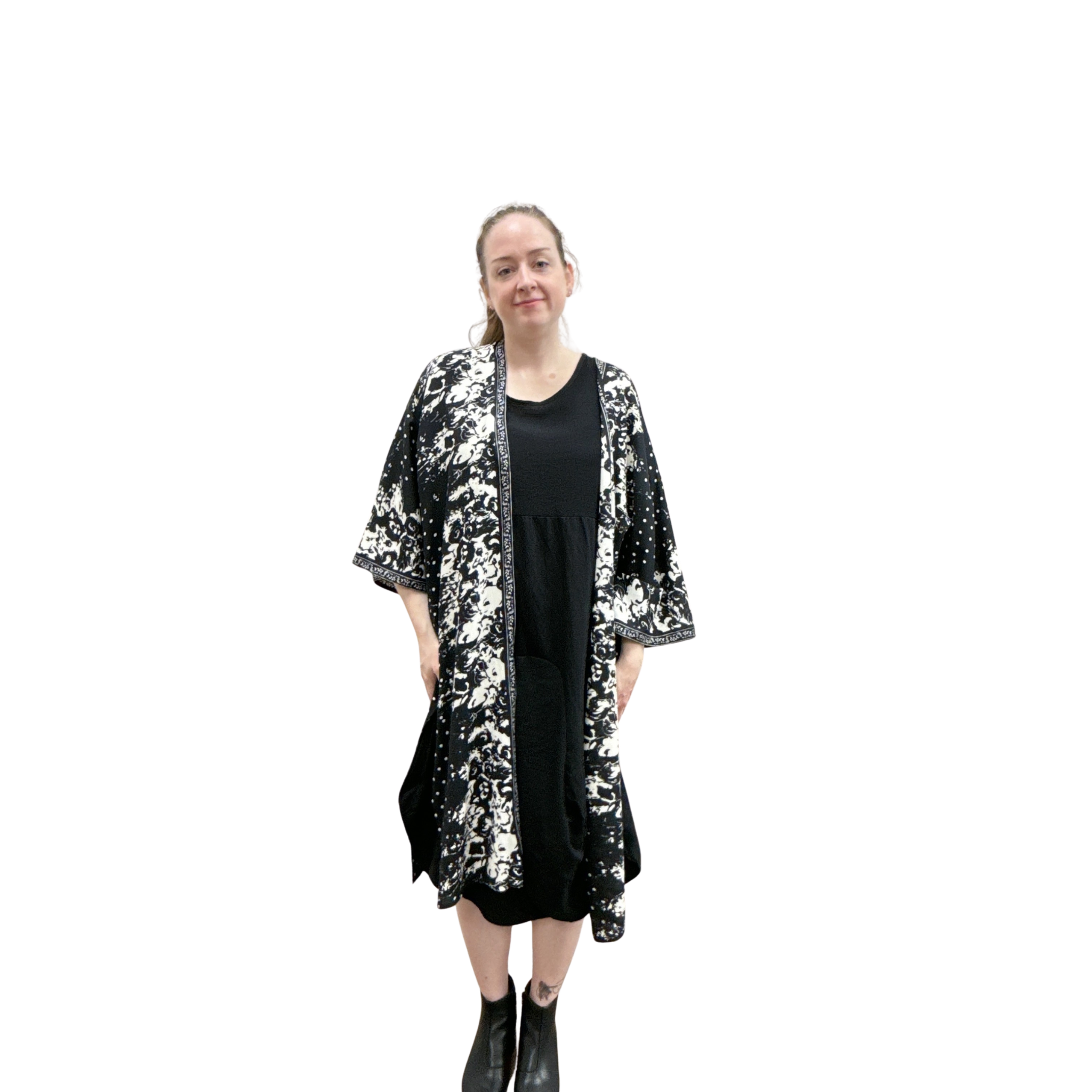 Woman wearing a black and white patterned kimono over a black dress on a white background