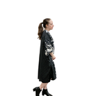 Woman wearing a black dress with white patterns on a white background
