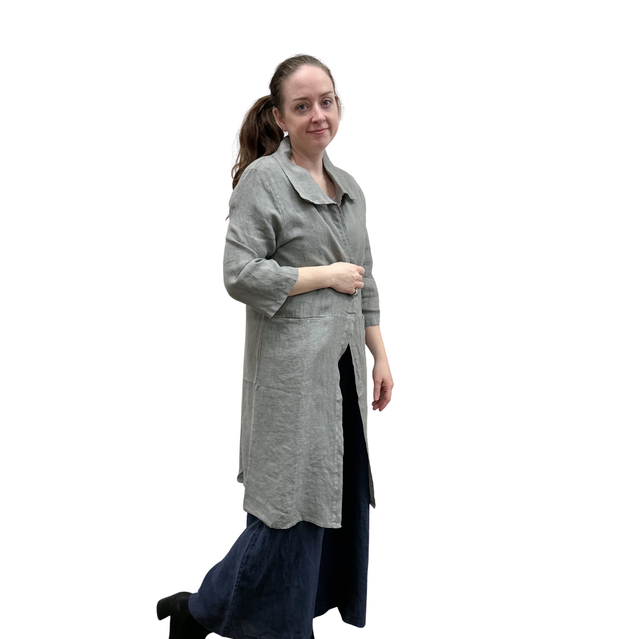 Woman wearing a long gray cardi over a dark jumpsuit on a white background