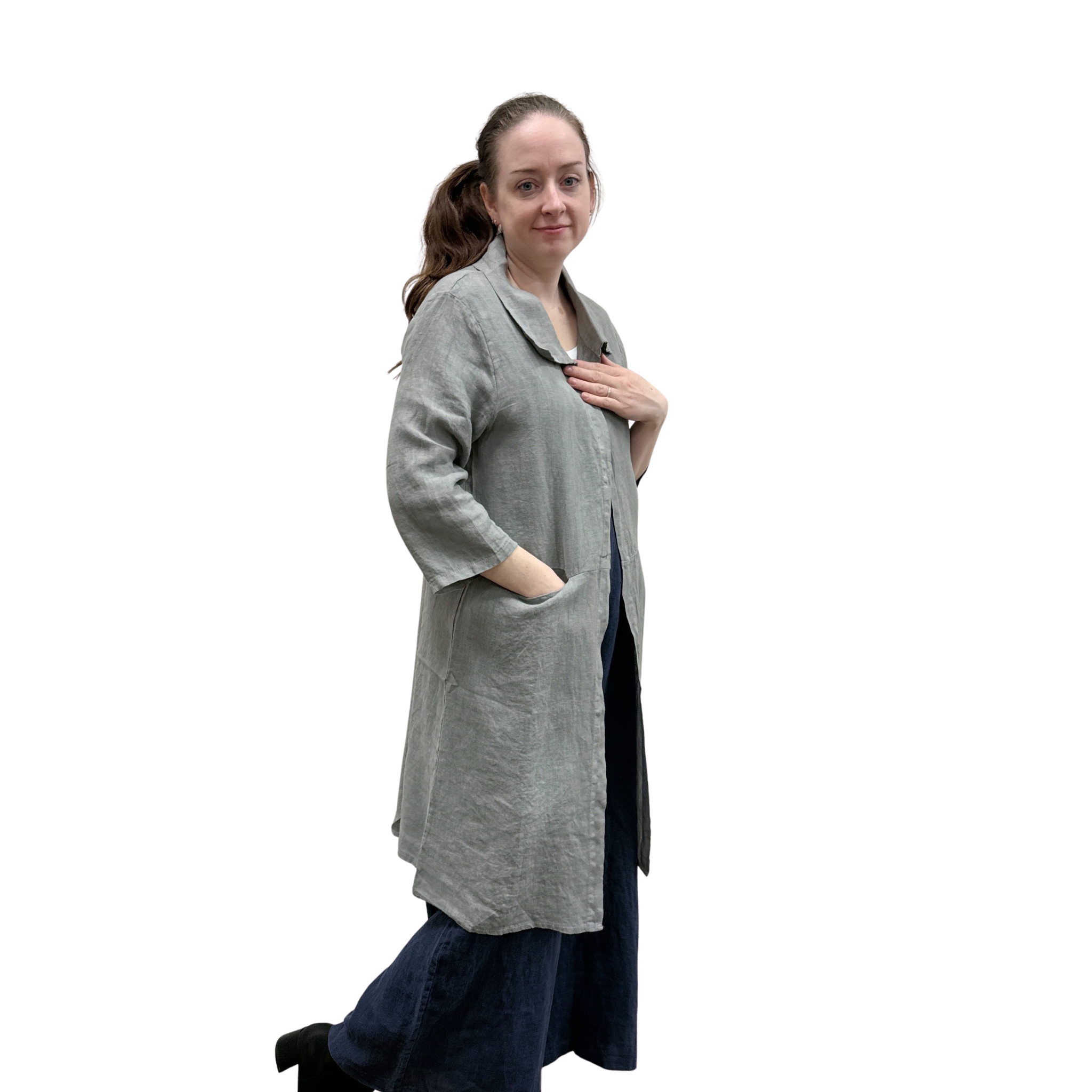 Woman wearing a long gray cardi over a dark jumpsuit on a white background