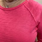 Close-up of a pink sleeveless top with a blurred background