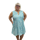 Woman wearing a blue floral dress on white background. 
