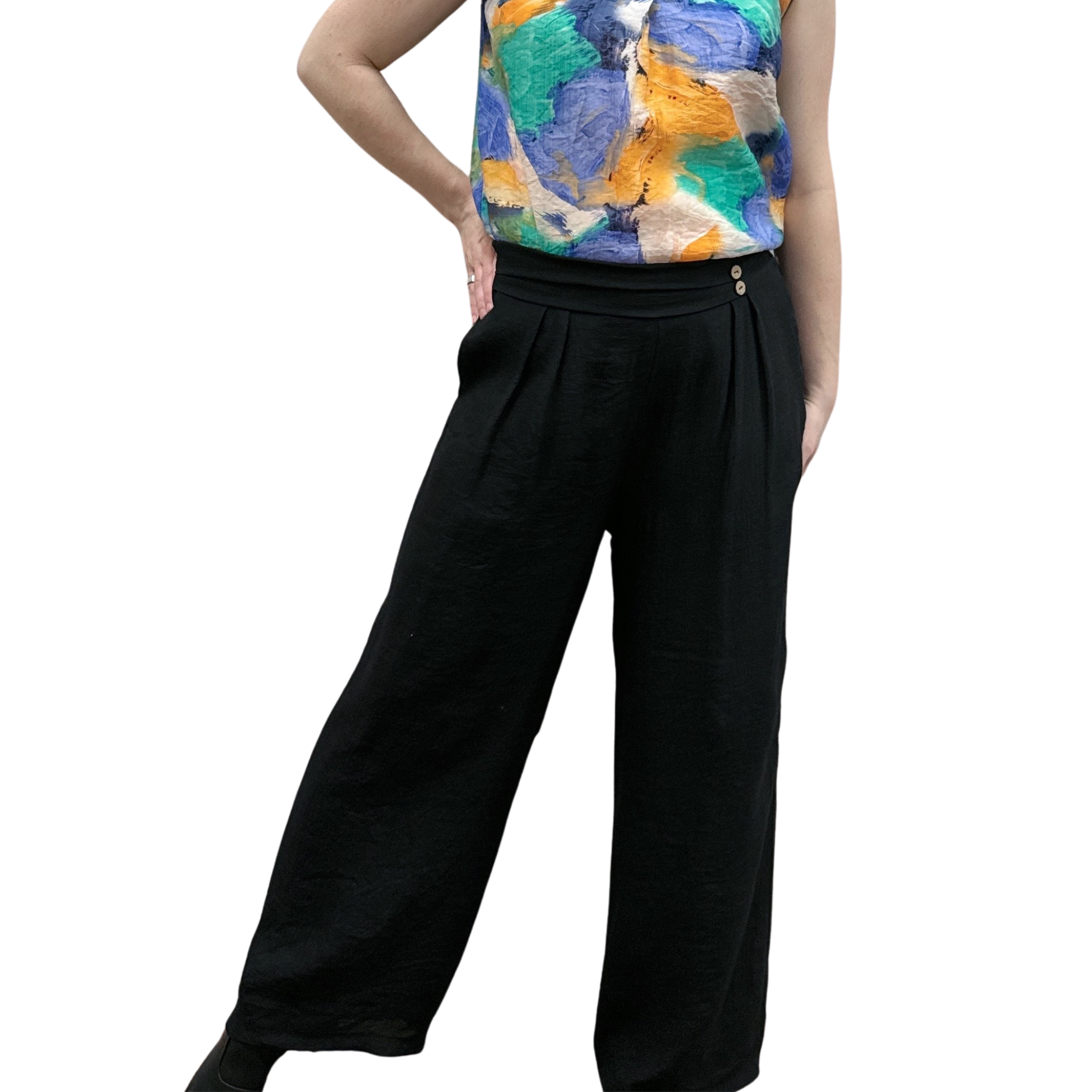 Person wearing a colorful top and black wide-leg pants on a white background