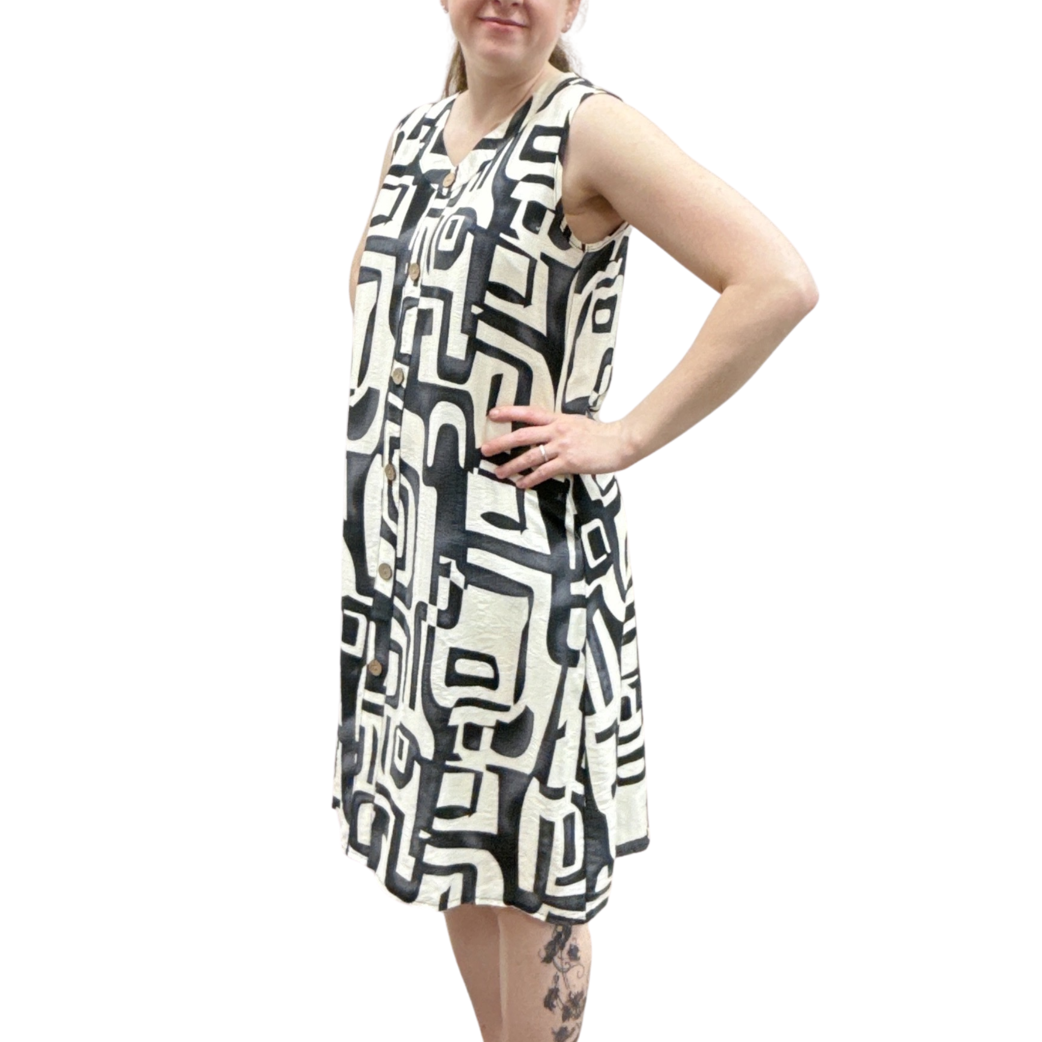 Woman wearing a sleeveless dress with a black and white geometric pattern on a white background