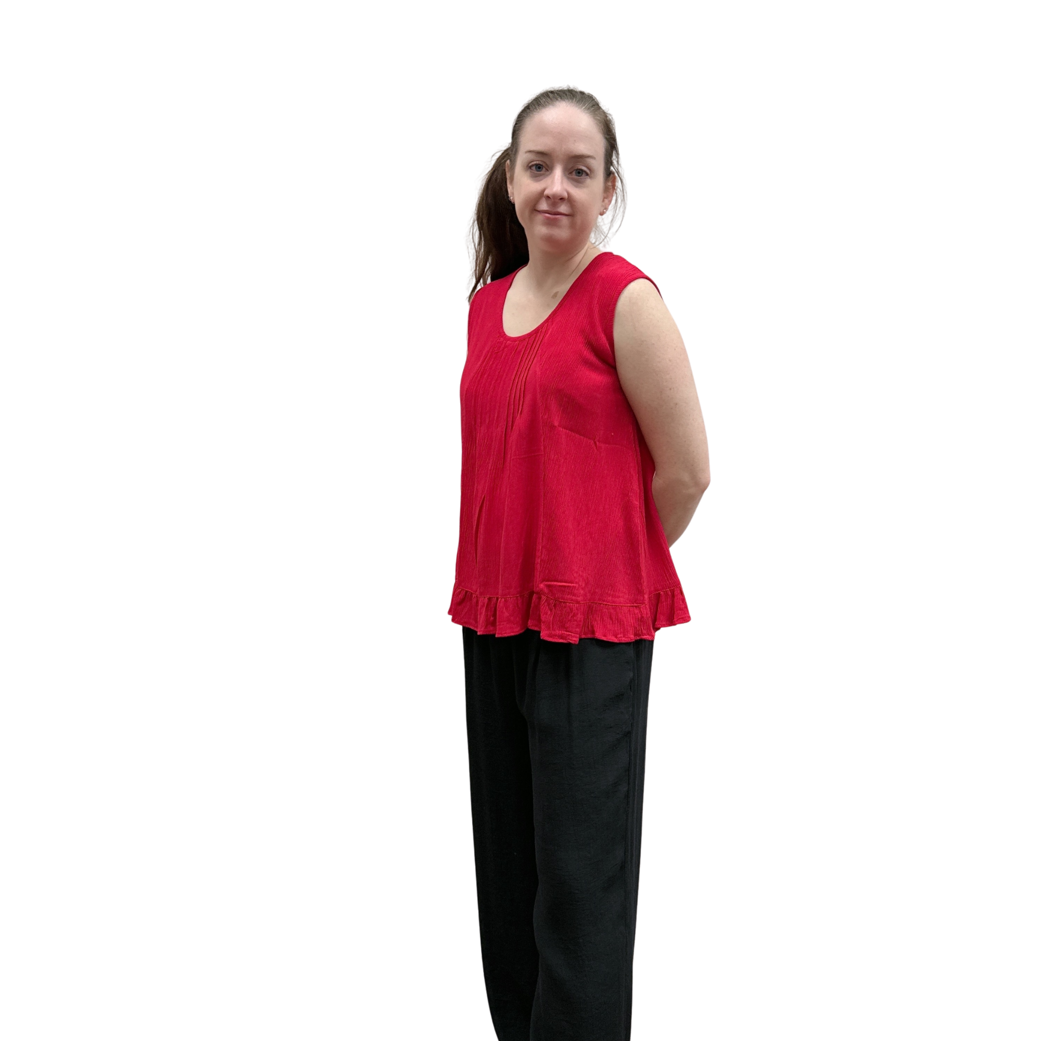 Woman wearing a red sleeveless top and black pants on a white background