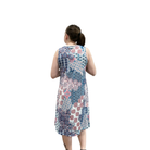 Woman wearing a sleeveless floral dress on a white background