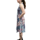 Woman wearing a sleeveless floral dress on a white background