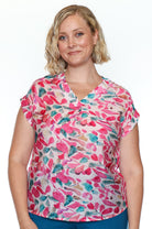 Woman wearing a colorful patterned shirt on a white background
