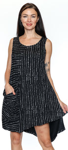 Woman wearing a black sleeveless dress with white patterns on a white background