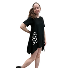 Woman wearing a black dress with white polka dots on a white background