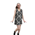 Woman wearing a black and white patterned sleeveless dress on a white background