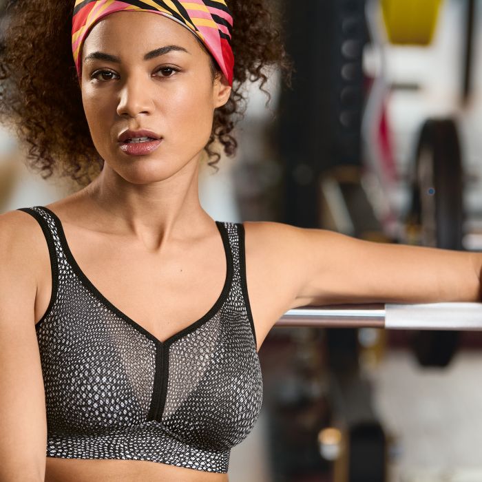 Woman in a sports bra and headband standing in a gym setting