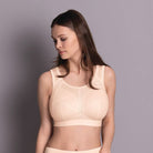 Woman wearing a beige compression garment against a gray background