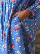 A persona wearing a blue dress with pockets