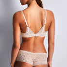 Aubade Rossence Plunge bra in Nude worn on a model against a white background, worn with matching panties from back view. 