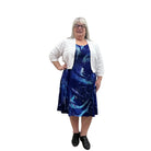 Woman wearing a white Blue Sky Aldi Sweater over a blue patterned dress on white background. 