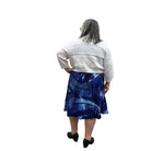 Woman wearing a white Blue Sky Aldi Sweater over a blue patterned dress on white background. 