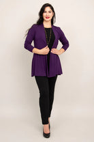 Woman wearing a purple blazer over a black top and pants on a beige background