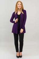 Woman wearing a purple blazer over a black top and pants on a white background
