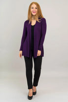 Woman wearing a purple cardigan over a black top and pants on a white background