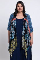 Woman wearing a floral kimono over a navy dress on a white background