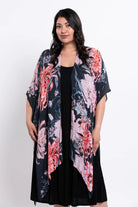 Woman wearing a floral kimono over a black dress on a white background